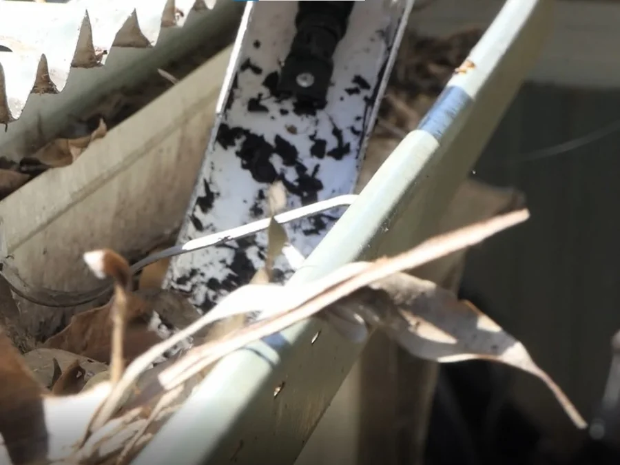 Gutter cleaner removing debris from a gutter